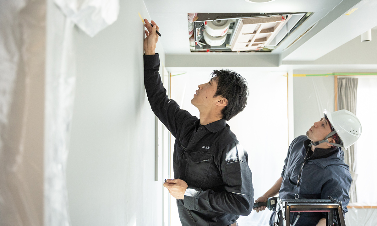 建材カタログを確認しながら話し合う2人の社員