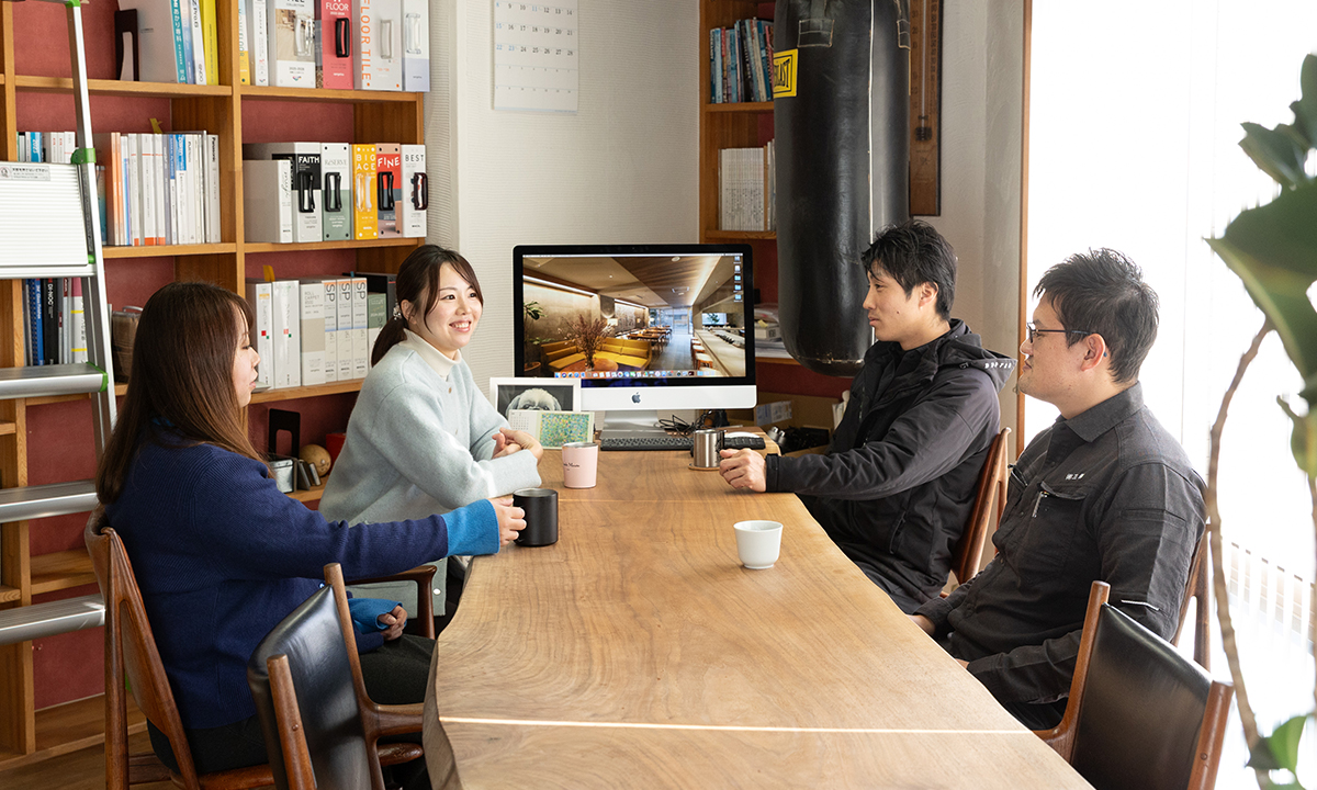 建材カタログを確認しながら話し合う2人の社員